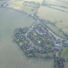 An aerial shot of Prospect Close which lies on the edge of Drayton Parslow. 2 Prospect Close is at the top left of the photo, where all the white vehicles are parked. The neighbouring field to the left directly borders the back-garden and the garage area. Notice also that 2 Prospect Close was at the head of the cul-de-sac, so neighbours would have to drive past it to access their own homes. The front-doors of the garage would have been highly visible.