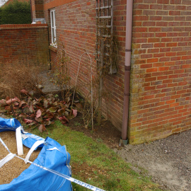 Notice the two gravelled areas. These are the areas of underpinning pre-dating the area by the garage in which Samuel's body was buried. The dimensions are near identical. In shot is a bag of sand for ongoing building works at the house.